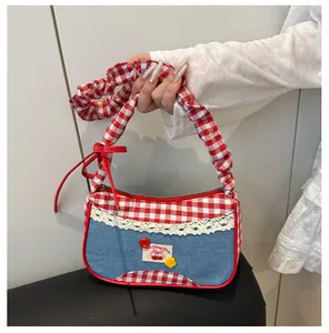 Detail of red gingham and denim patchwork handbag with lace trim and cherry patch