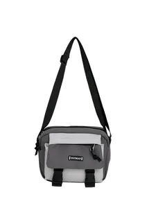 Detail of color-block canvas crossbody bag with adjustable strap and buckle closure