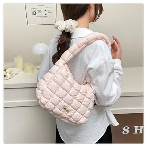 Gros plan du sac en coton matelassé rose clair avec texture douce et boucle dorée