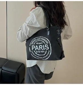 Detail of the black canvas tote bag showing the vintage Paris print and sturdy handles