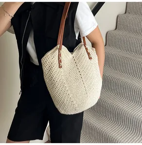 Detail of cream woven tote bag with brown leather straps and V-shaped knit texture