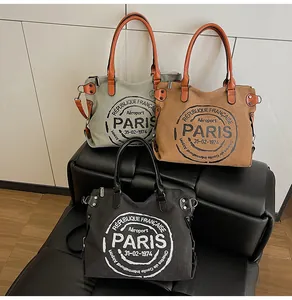 Detailed view of canvas tote bags in green, camel and black with vintage French prints