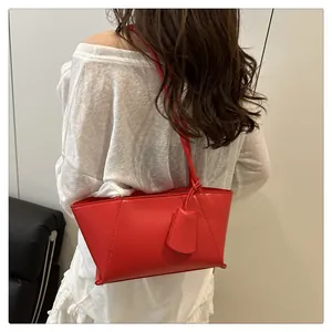 Detail of red leather tote bag showing fine stitching and minimalist geometric lines