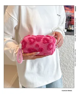 Detail view of pink plush clutch bag made of faux lamb wool with heart texture