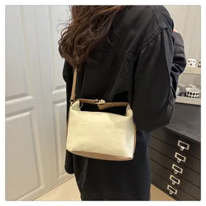 Détail du sac à bandoulière beige à rayures verticales avec garniture en cuir marron