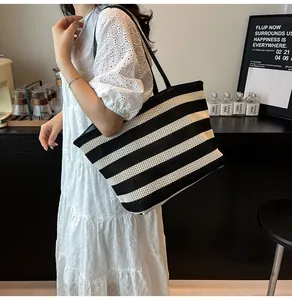 Vista de detalle del bolso tote tejido a rayas blancas y negras con correas de hombro largas
