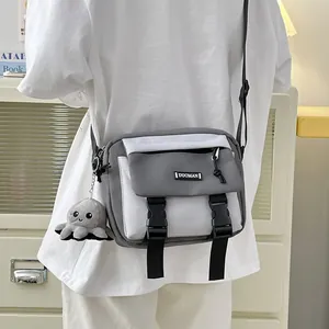 Minimalist grey and white canvas crossbody bag with octopus charm shown on model