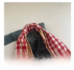 Detail of red and white plaid tote bag handle with high-quality cotton stitching