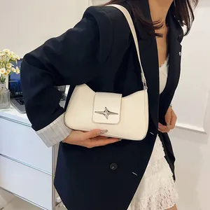 Sac sous le bras baguette blanc avec boucle étoile argentée porté par une mannequin