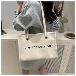 Casual lifestyle view of beige canvas tote bag with Limited Edition print for daily commute
