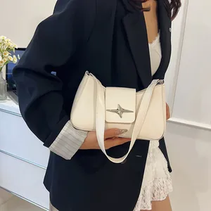 Détail d'un sac sous les aisselles chic en cuir crème avec boucle étoile argentée