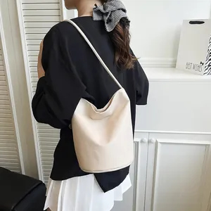 Minimalist cream white pebble leather bucket bag with slim shoulder strap for daily wear