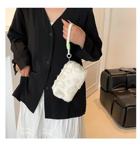 Close-up of white plush handbag with textured pattern and bright green accent ring
