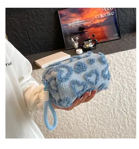 Close-up of soft plush cosmetic bag with 3D heart patterns and hand strap detail