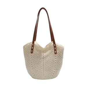 Beige woven beach tote bag with V-pattern texture and dark brown leather shoulder straps