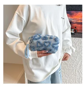 Close-up of sky blue plush heart patterned clutch bag with a detachable wrist strap