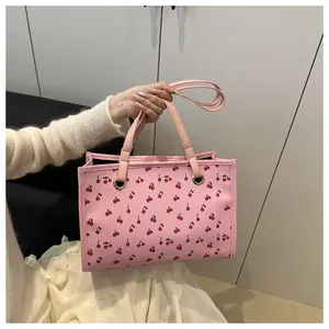 Détail du sac cabas rose imprimé cerises avec œillets argentés et doubles poignées