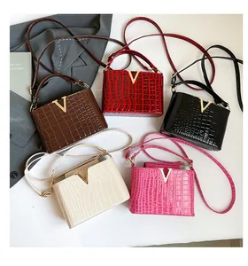 Detail showing five crocodile pattern tote bags with gold V hardware and slim straps