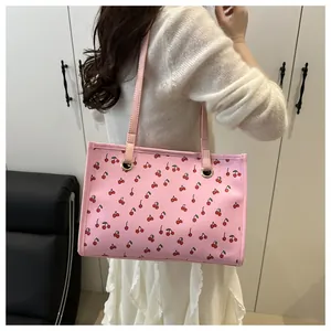 Detailansicht der rosa Tragetasche mit Kirschmuster, die ein Modell für das Styling trägt