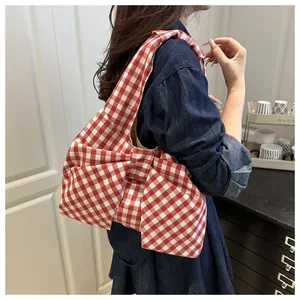 Detail view of red gingham tote bag featuring a large bow and soft fabric texture