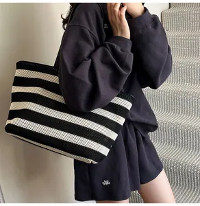 Bolso tote de punto con rayas blancas y negras de gran capacidad llevado al hombro