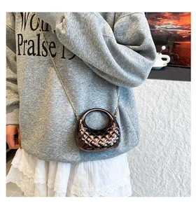 Glossy bronze quilted mini bag featuring a circular handle and gold chain on model