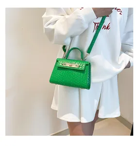 Détail du mini sac vert à texture crocodile avec fermoir doré et poignée élégante