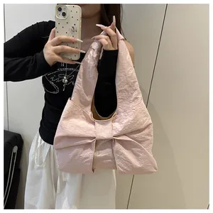 Detail of pink bow-shaped tote bag showing subtle pleated texture and soft fabric