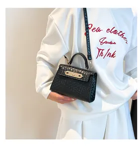 Détail du mini sac noir tressé avec fermoir doré porté par un mannequin à la taille