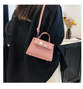 Detailed view of pink woven texture mini handbag with gold twist lock and adjustable strap