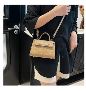 Détail du sac à main kaki avec texture pierre et boucle argentée porté en bandoulière