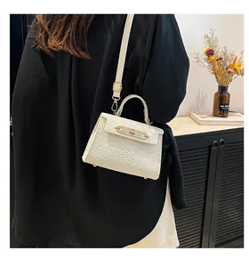 Vue portée d'un mini sac blanc à motif crocodile avec fermoir doré et bandoulière