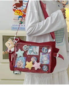 Detail view of red ita bag with clear window showing anime badges and postcards