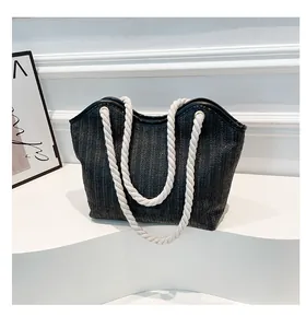 Detail of the woven texture and white cotton rope handles on the grey tote beach bag