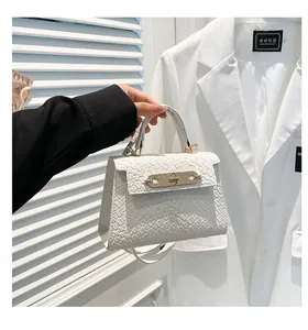 Détail d'un sac à main blanc à texture tressée avec boucle dorée et poignée ronde