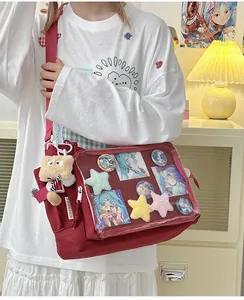 Macro detail of a dark red ita bag with a clear window and various anime pins inside