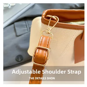 Nahaufnahme des verstellbaren braunen Leder-Schultergurts mit goldener Hardware an Webtasche