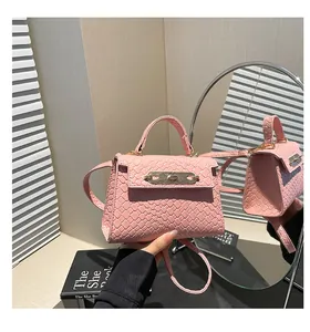 Close-up of pink woven texture handbag with golden metallic twist lock and handle