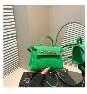 Detail view of green woven leather bag with gold clasp reflected in a mirror