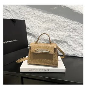 Detailed close-up of khaki crocodile embossed leather texture and metallic clasp closure