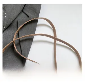 Detail of light khaki shoulder strap with neat stitching on smooth faux leather bag