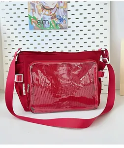 Close-up of a deep red ita bag featuring a large clear PVC window and fashion label