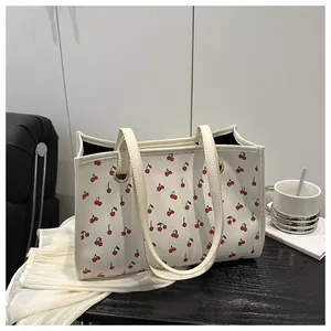 Détail du sac cabas crème avec imprimé cerises et anses d'épaule en cuir PU souple