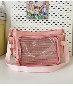 Pink crossbody bag detail with transparent front mesh pocket and side fashion labels