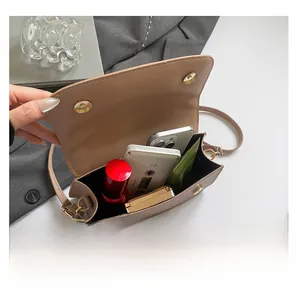 Internal capacity of khaki shoulder bag showing space for phone and makeup