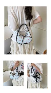 Détails du sac croissant bleu avec nœuds rouges, bordure noire et finitions argentées
