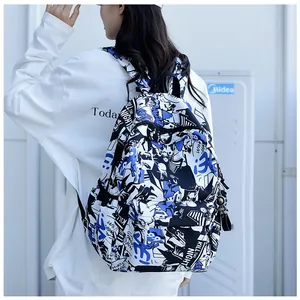Street style backpack with graffiti print and astronaut charm worn by a model