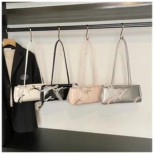 Chic baguette bags with lace bows and pearl charms in multiple colors on display