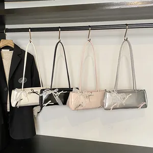 Minimalist baguette shoulder bags in glossy leather with lace bows and pearl charms