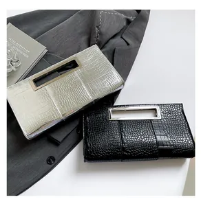 Detail of silver and black textured leather clutches with modern metal cutout handles
